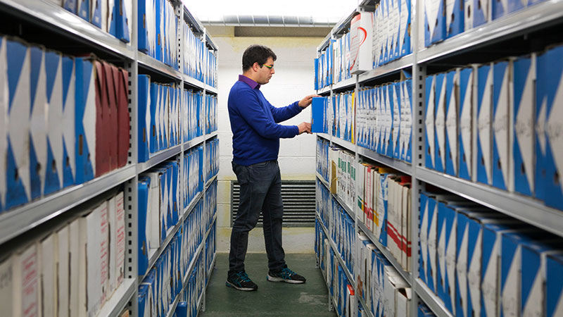 Jeune archiviste dans un magazin d'archive