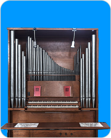 Instrument de musique comportant un clavier et une série de tuyaux (sur fond bleu).