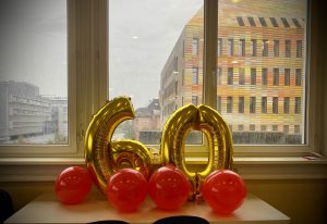 Des ballons en forme du chiffre 60, posés sur une table, avec en fond le CRBS.